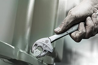 [Translate to Englisch:] Der selbstjustierende Maulschlüssel Joker 6004 stellt die benötigte Größe beim Ansetzen an der Sechskant-Mutter oder -Schraube stufenlos von selbst ein. Durch die Nutzung der Eckweiten-Prismen im vorderen Teil des Mauls ist ein Rückschwenkwinkel von nur 30° für das Arbeiten auf engstem Raum möglich.